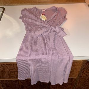 Brand new purple / mauve ish color dress with bow! Crossover deep neck line.
